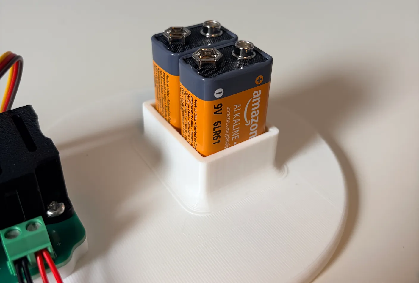 Robotic Arm build — Start with the Base: Unwrap the two 9-volt batteries and put them in their slot to power the robot.