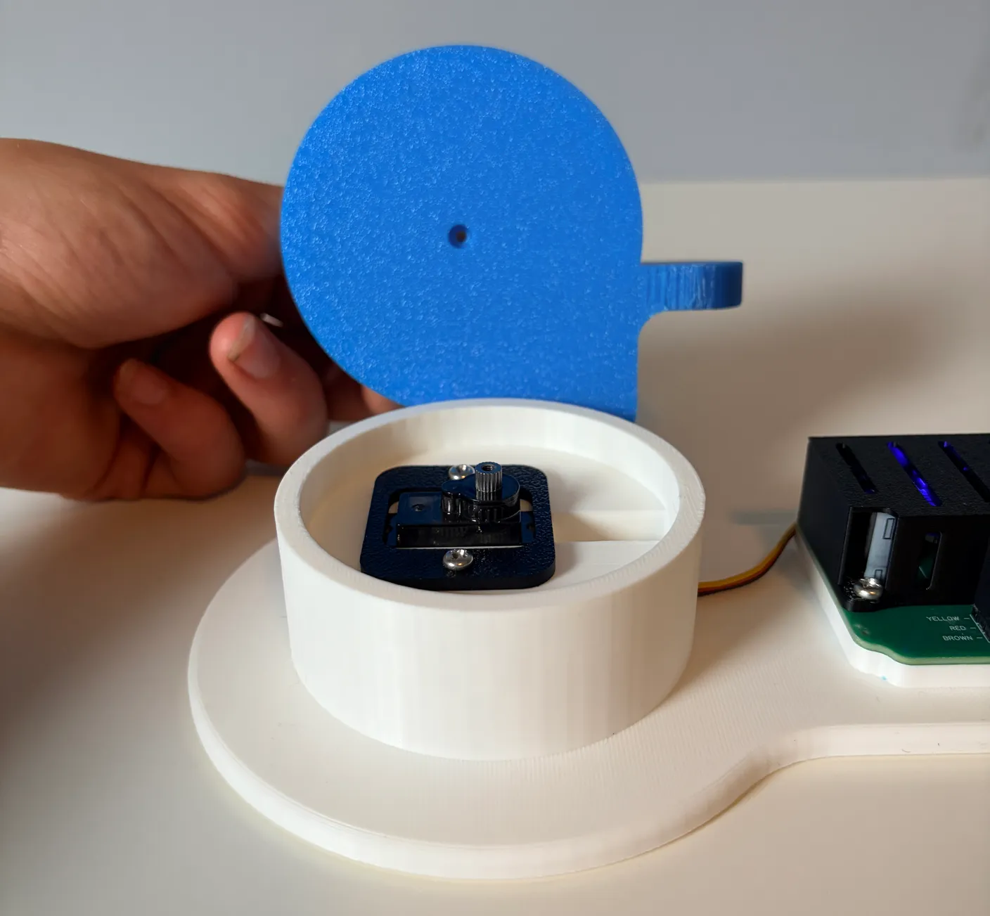 Robotic Arm build — Assemble the First Half of the Arm: Notice the hole on the bottom of the blue part, which lines up with the servo.