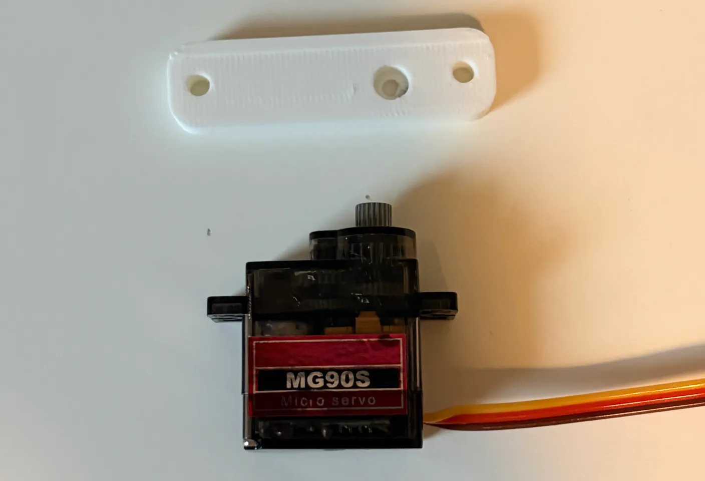 Robotic Arm build — Assemble the Other Half of the Arm: Lay the servo down and position the small rectangle piece as in the image.