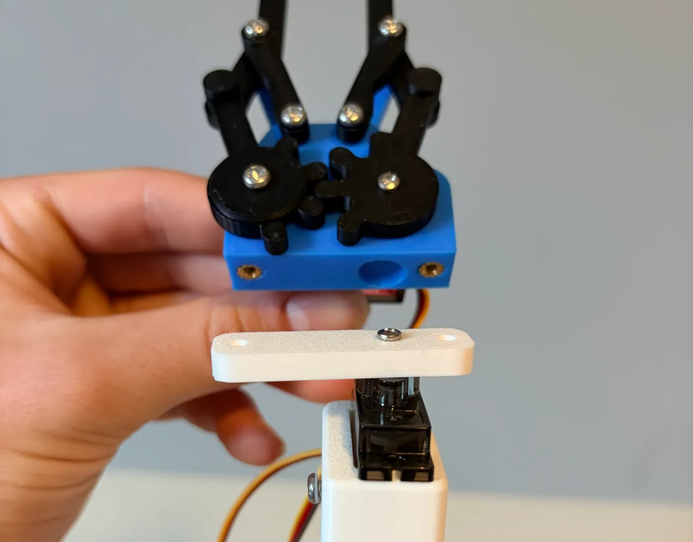 Robotic Arm build — Attach the Gripper: Rotate the white bar into position and line the gripper up with the top of the robot.