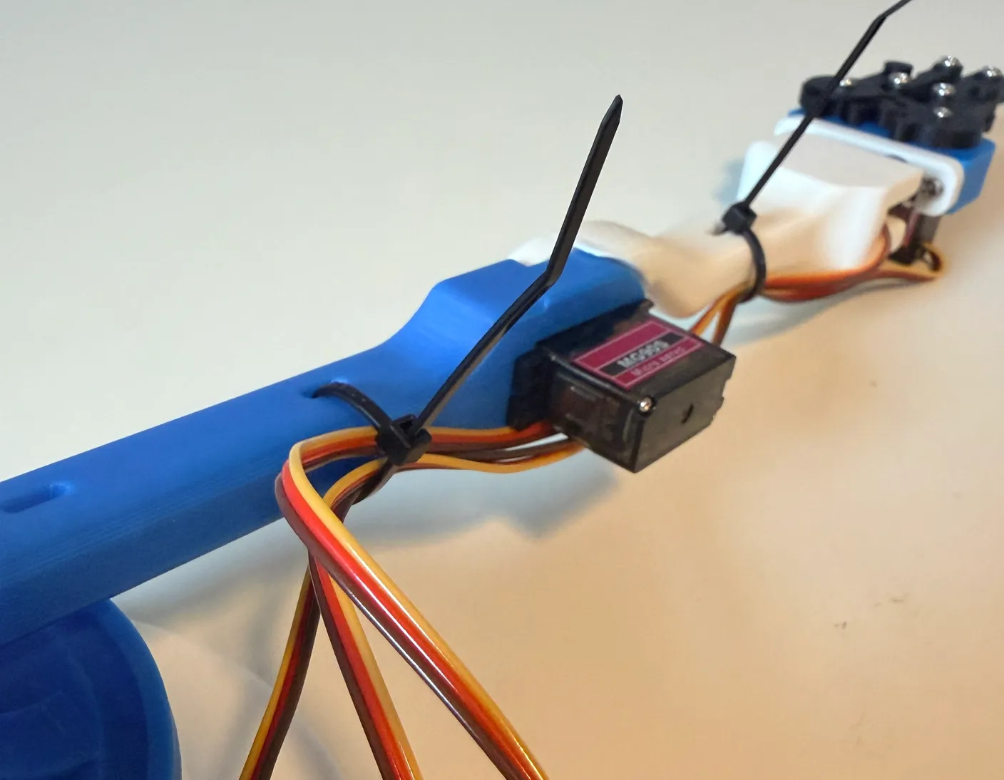Robotic Arm build — Wire Management: Add another zip tie through the blue arm to bundle the elbow, wrist, and gripper wires.