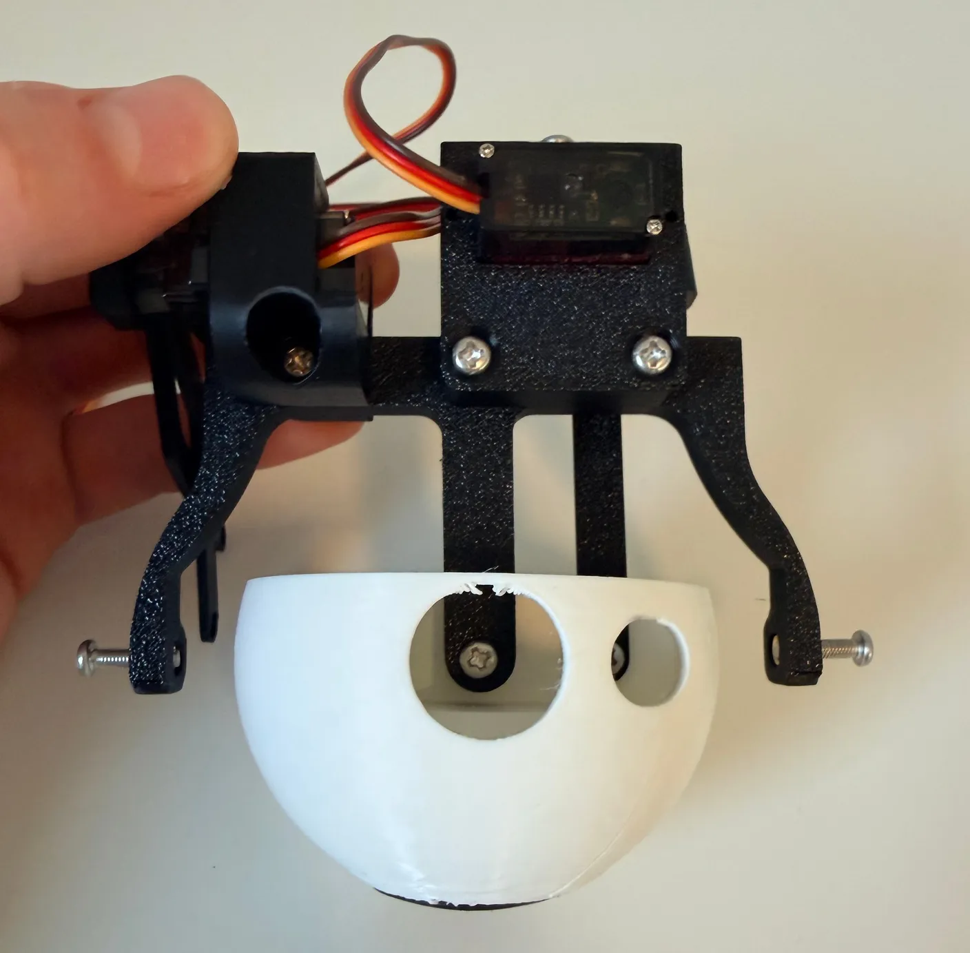 Robotic Eyes build — Assemble the Eyes: Now, using two 12mm screws, screw them into the holes on the outside of the assembly, as shown below.