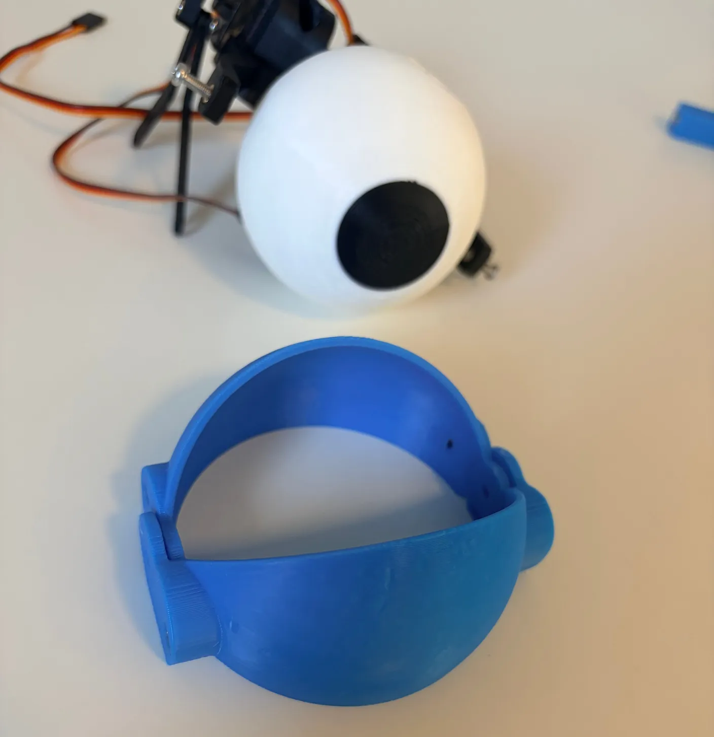 Robotic Eyes build — Assemble the Eyes: Now, get a pair of eyelids and lay them flat on the table like this.