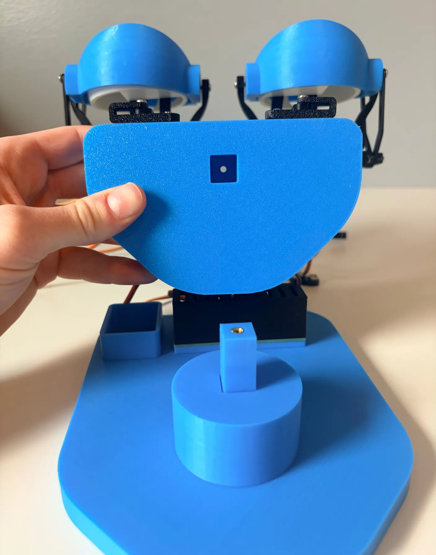 Robotic Eyes build — Assemble the Base: Now, line up the square hole on the eye assembly with the pin you just screwed into the base.