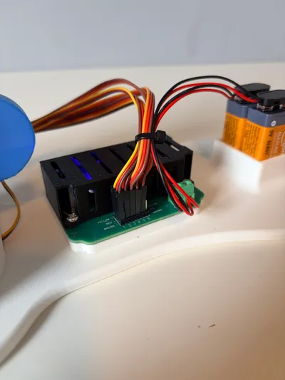 Close-up of the Robotic Arm Kit's control board and wiring harness mounted on the base