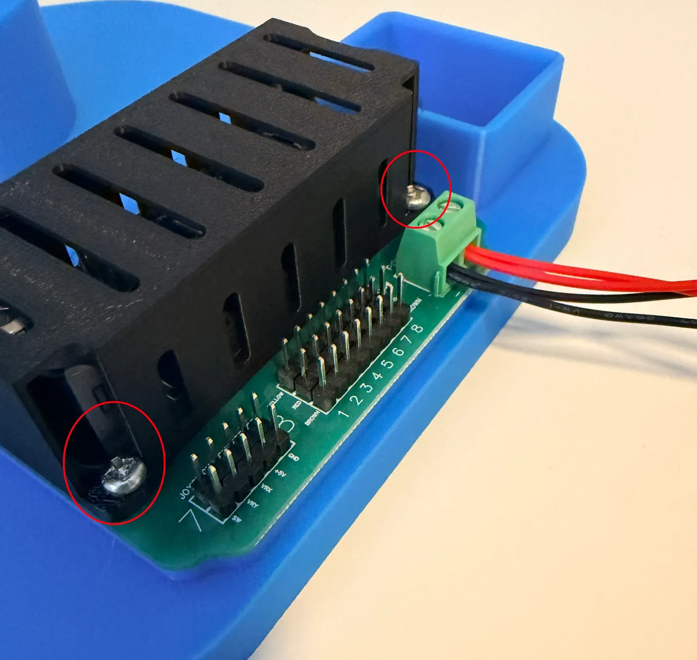 Robotic Eyes build — Swap from Joystick to Wireless: The two screws holding the control board to the base, circled in red.
